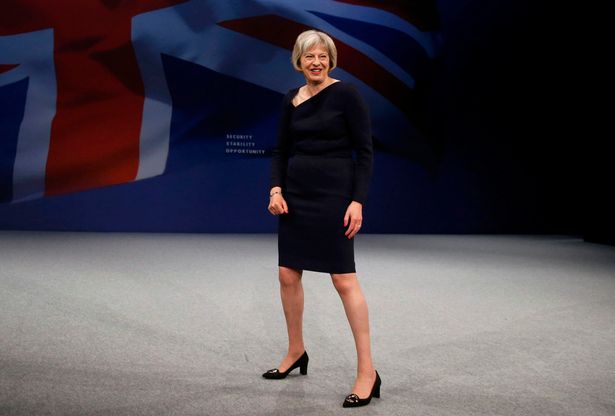 Theresa May onstage akimbo